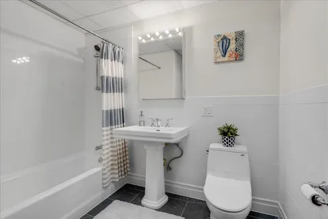 a bathroom with a toilet sink and mirror