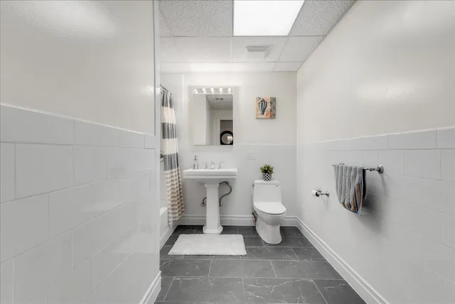 a bathroom with a toilet sink and mirror