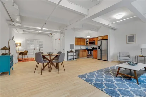 a living room with furniture a dining table and a wooden floor