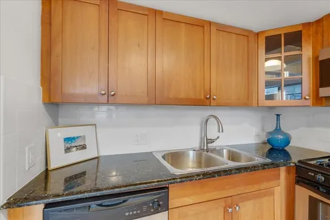 a kitchen with granite countertop a sink cabinets and window