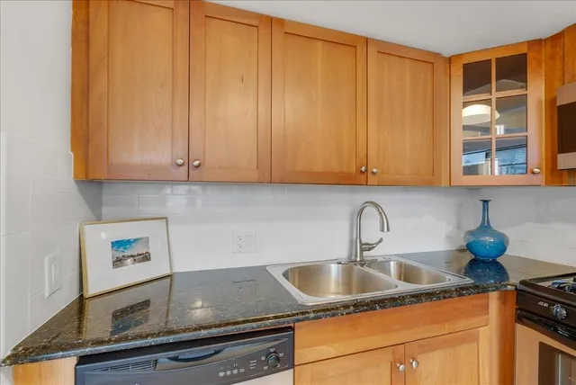 a kitchen with granite countertop a sink cabinets and window