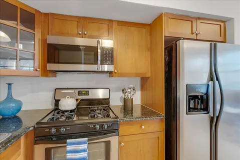 a kitchen with granite countertop a sink cabinets and window