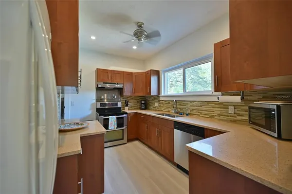 a kitchen with stainless steel appliances granite countertop a sink stove and refrigerator
