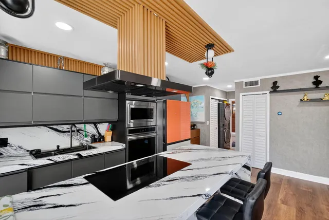 a kitchen with stainless steel appliances kitchen island granite countertop a sink and cabinets