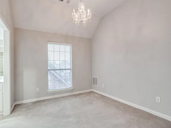 an empty room with windows and chandelier