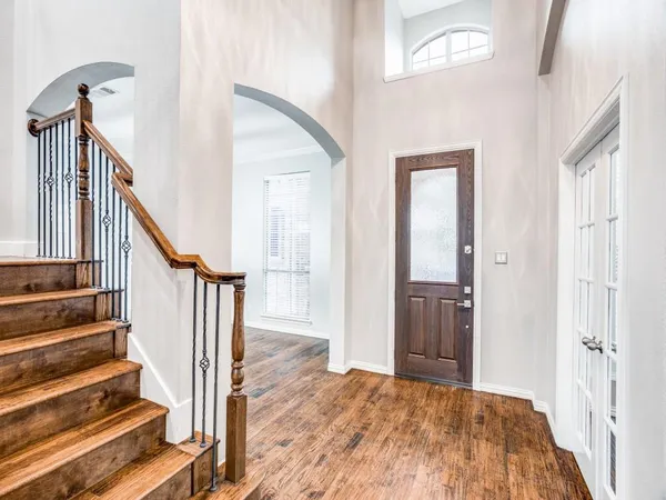 a view of a hallway with wooden floor and staircase