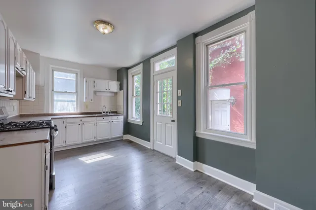 a kitchen with granite countertop a stove a sink and a refrigerator