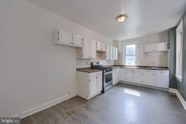 a kitchen with granite countertop white cabinets and white appliances