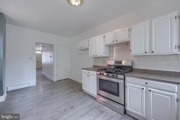 a kitchen with a stove top oven and cabinets