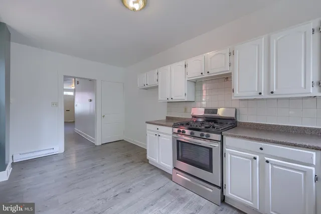 a kitchen with a stove top oven and cabinets