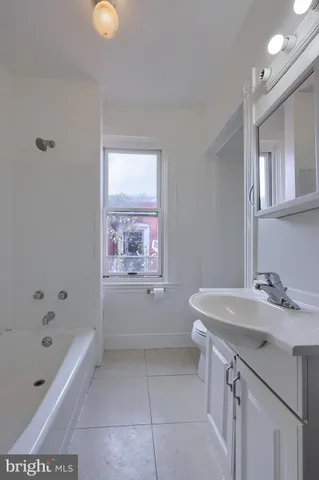 a bathroom with a bathtub a sink a toilet and mirror