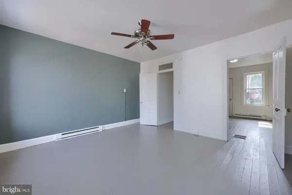 a view of a livingroom with wooden floor and a ceiling fan