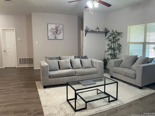 a living room with furniture and a potted plant