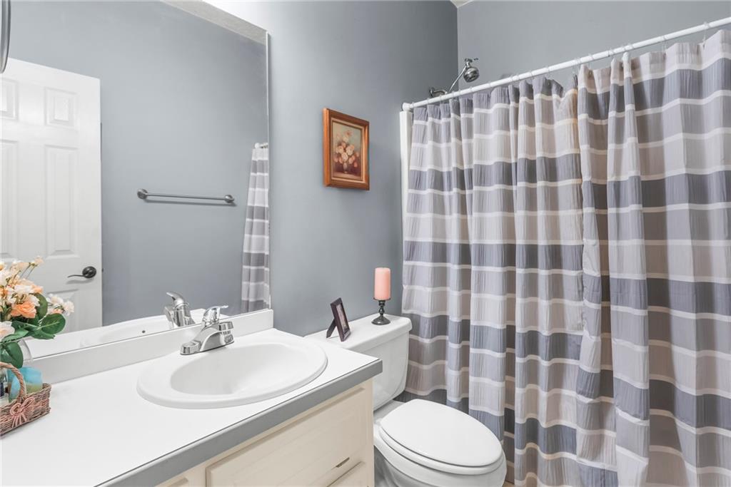 826 Hampton Way Canton, GA 30115 - Photo 15 of 17 a bathroom with a sink a toilet a shower and a mirror