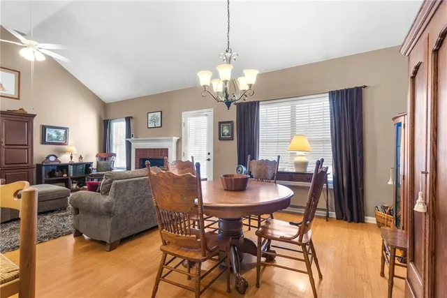 a view of a dining room with furniture a chandelier and a window