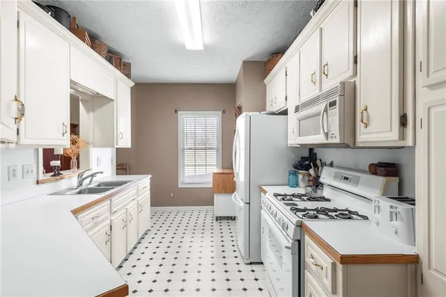 a kitchen with stainless steel appliances a stove a sink and a refrigerator