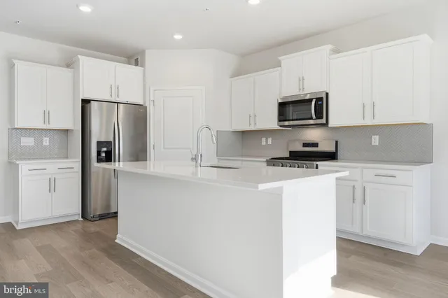 a kitchen with cabinets stainless steel appliances and a counter space