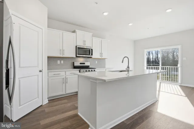 a kitchen with appliances a sink and cabinets