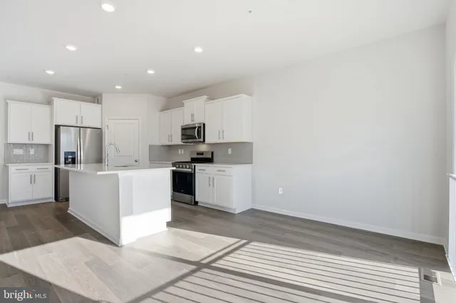 a large white kitchen with cabinets