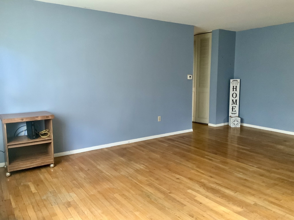 109 Regency Park Drive, Unit 109 Agawam, MA 01001 - Photo 5 of 17 a view of an empty room with wooden floor and a fireplace
