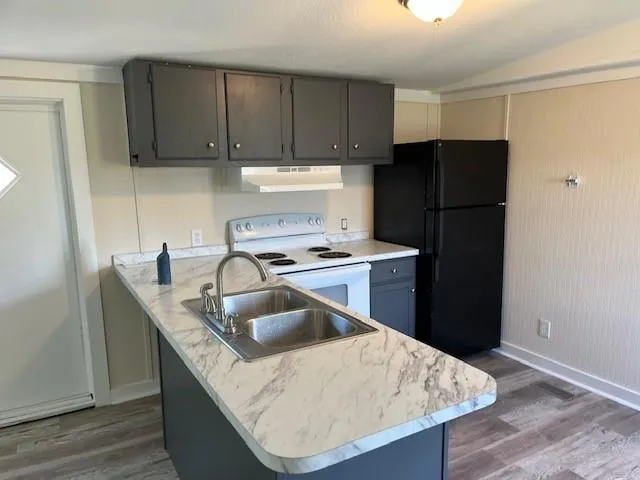 a kitchen with kitchen island a refrigerator sink and stove