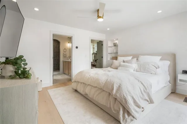 a spacious bedroom with a bed and a potted plant