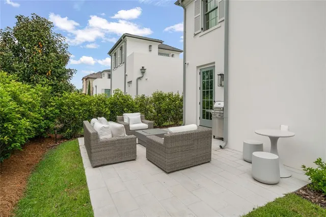 a view of a patio with couches table and chairs and potted plants