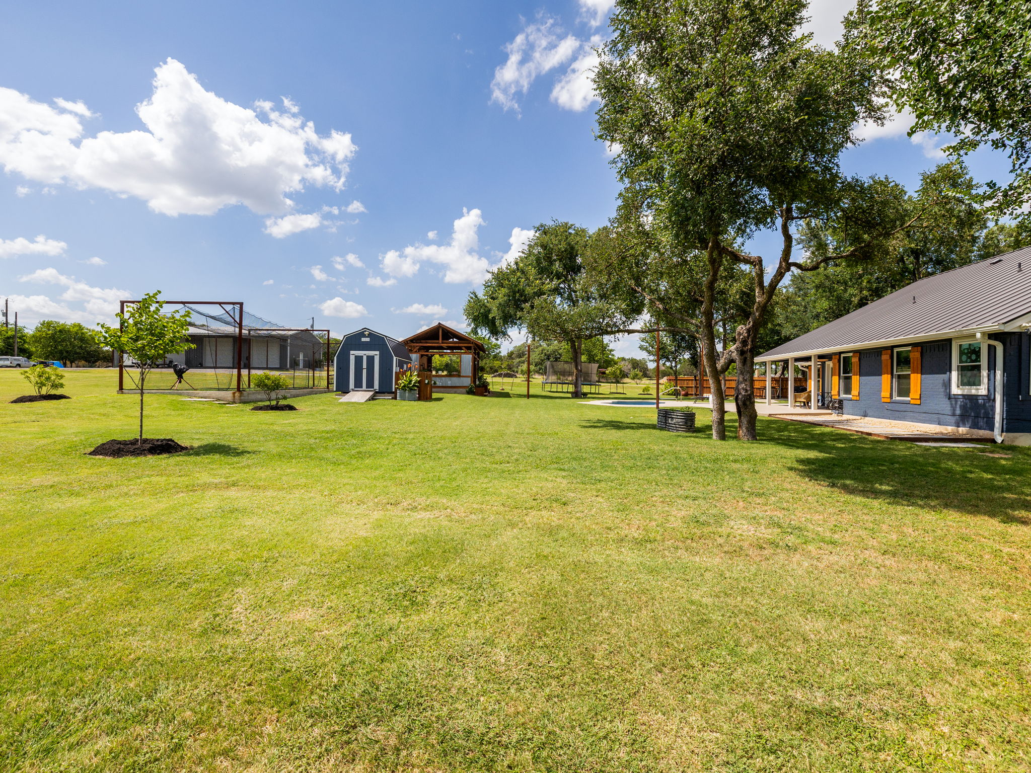 3001 County Road 255 Georgetown, TX 78633 - Photo 26 of 35 Your cherished outdoor space features a pool, lush lawn, and charming outbuildings for storage.