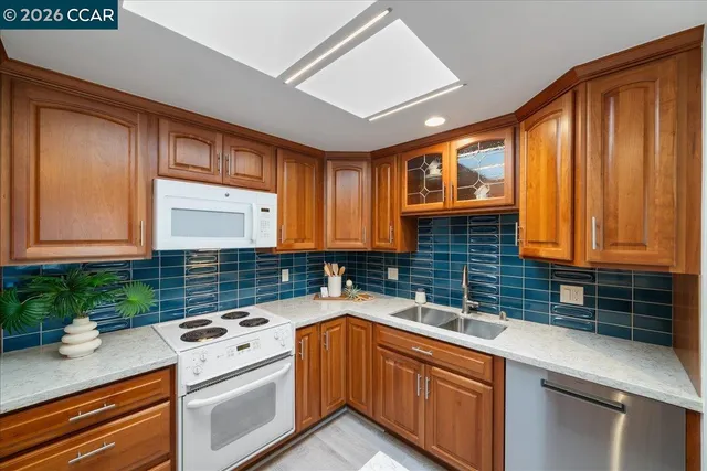 a kitchen with stainless steel appliances granite countertop a sink a stove and cabinets