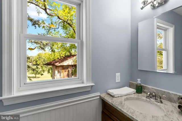 a bathroom with a granite countertop sink and a window