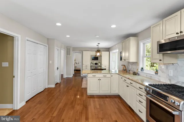 a large kitchen with cabinets wooden floor and stainless steel appliances