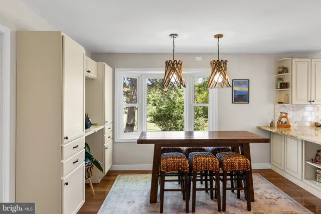 a kitchen with stainless steel appliances a table and chairs in it