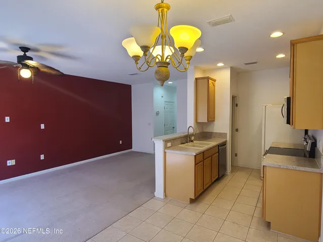 a kitchen with stainless steel appliances granite countertop a sink a stove top oven and cabinets