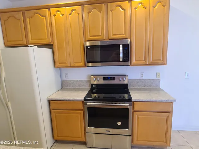 a kitchen with wooden cabinets and a stove top oven