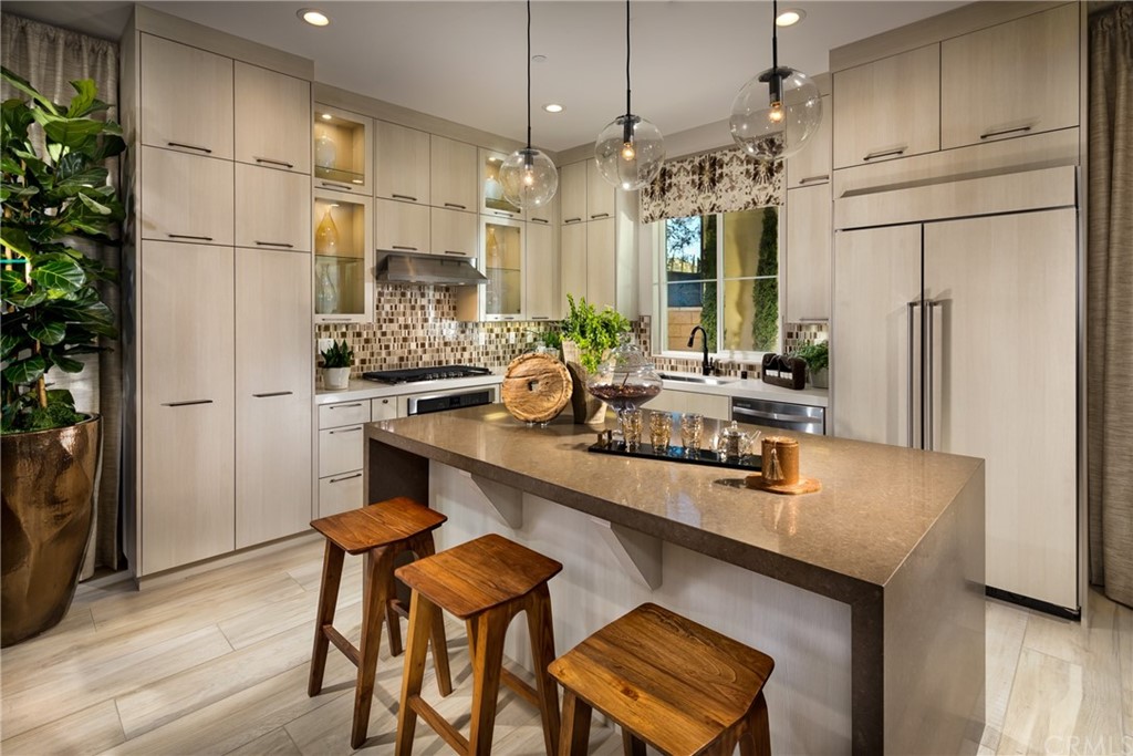 20740 Bur Oak Circle Porter Ranch, CA 91326 - Photo 4 of 10 a kitchen with stainless steel appliances a table chairs refrigerator and sink