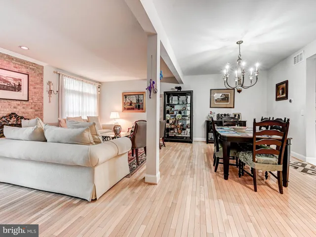 a living room with furniture a dining table and a chandelier