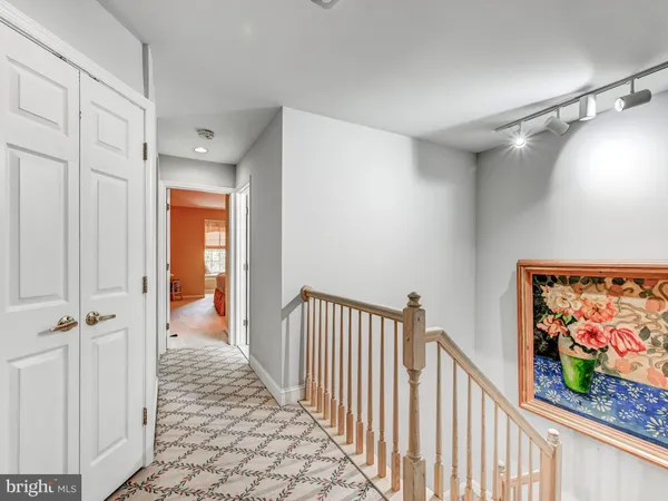 a view of a hallway with wooden floor and staircase