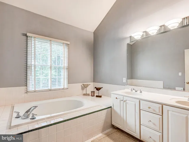 a bathroom with a tub sink and mirror