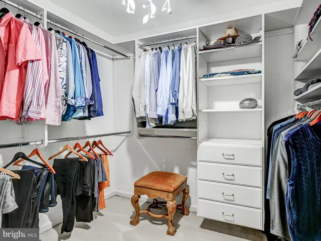 a view of walk in closet with clothes and shoes