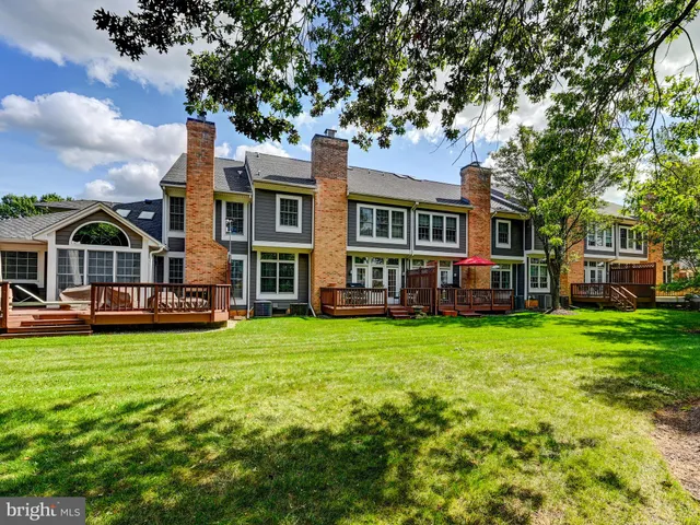 a view of a house with a big yard plants and large trees
