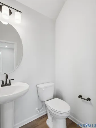 a bathroom with a toilet a sink and mirror