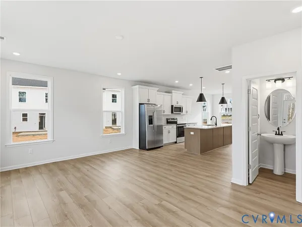 a living room with stainless steel appliances kitchen island wooden floors and view living room