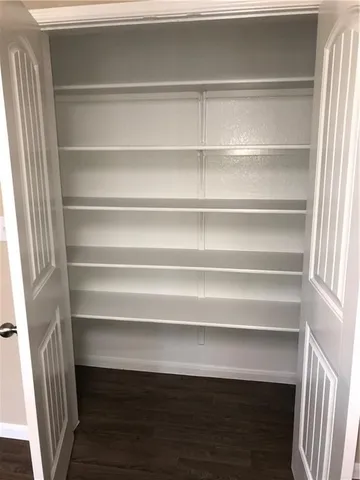 a view of walk in closet with empty racks