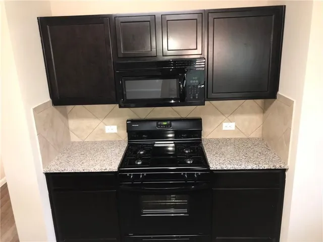 a kitchen with granite countertop stainless steel appliances and cabinets