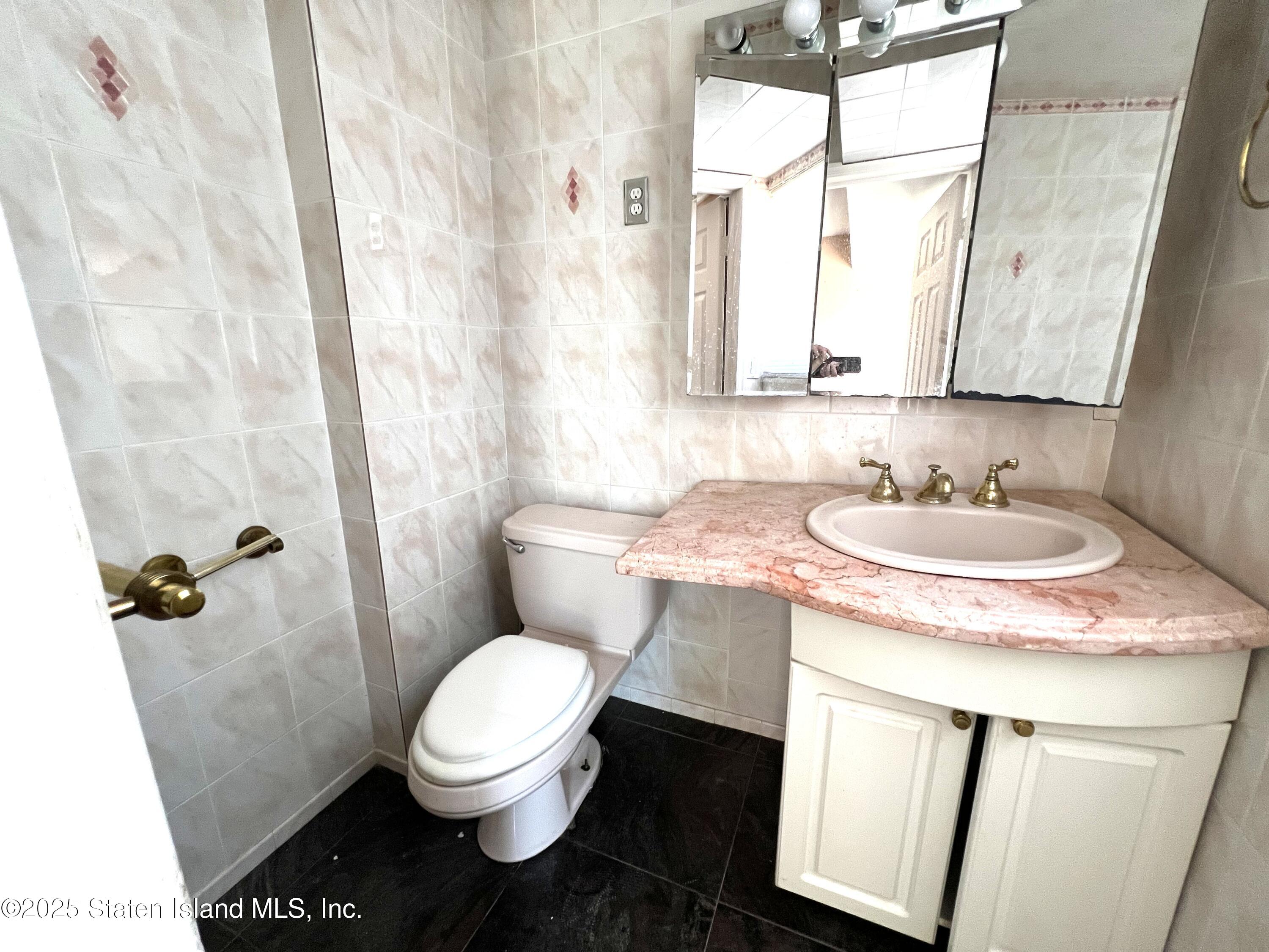 85 Foster Road Staten Island, NY 10309 - Photo 14 of 34 a bathroom with a granite countertop sink toilet and shower