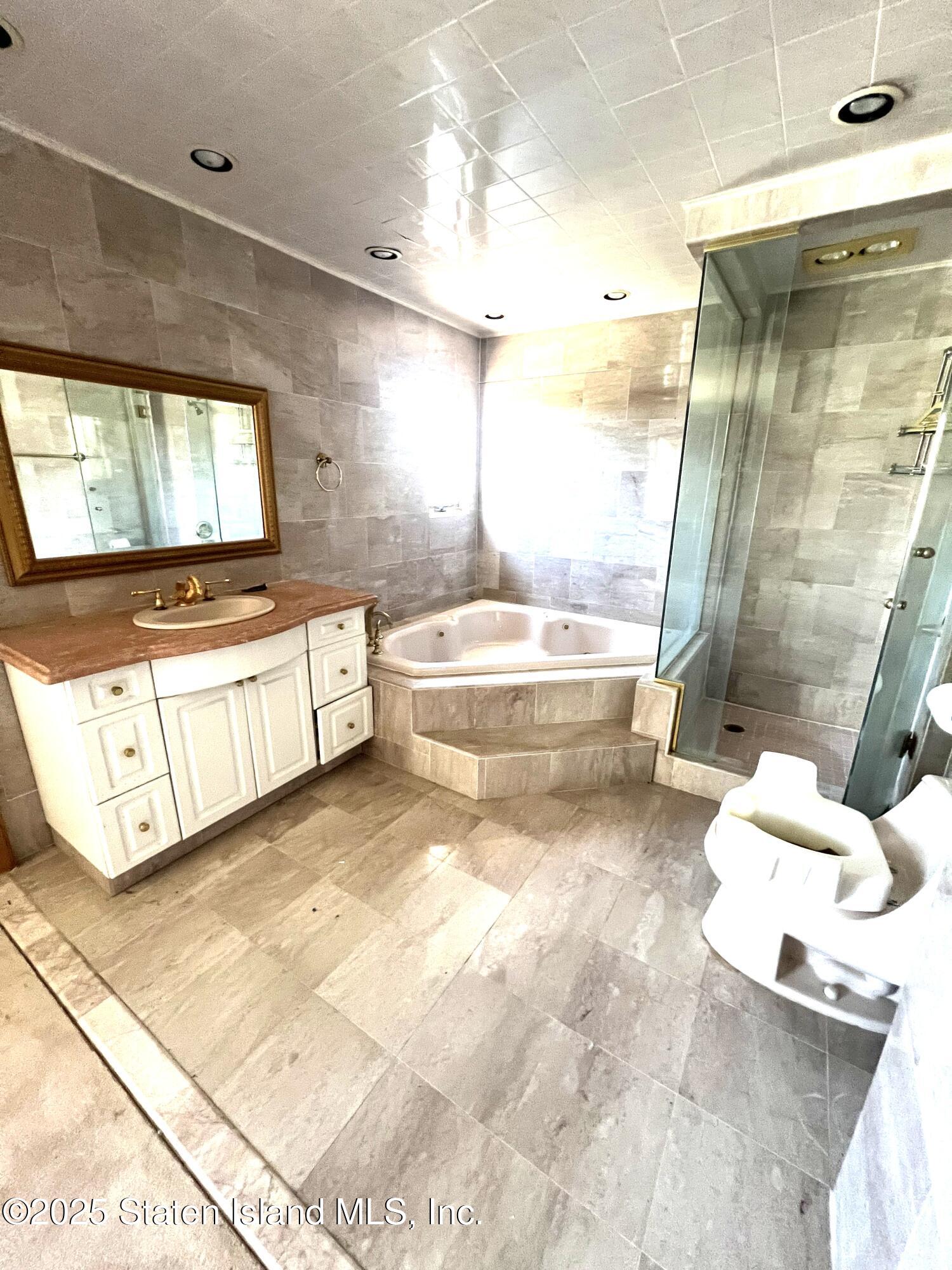 85 Foster Road Staten Island, NY 10309 - Photo 23 of 34 a bathroom with a bathtub sink mirror and toilet