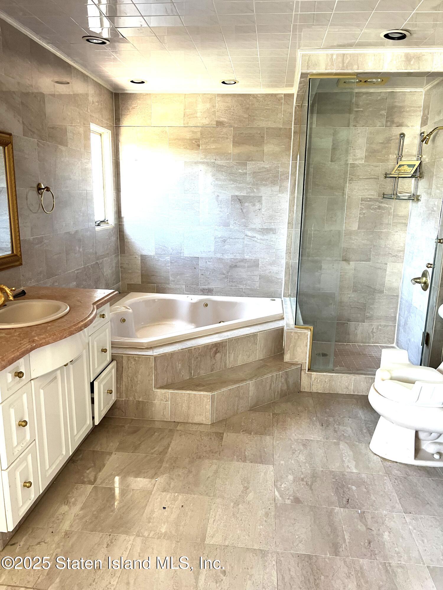85 Foster Road Staten Island, NY 10309 - Photo 24 of 34 a bathroom with a bathtub sink mirror and toilet