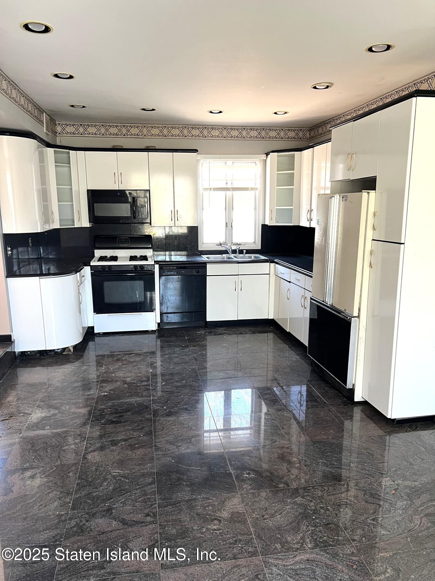 85 Foster Road Staten Island, NY 10309 - Photo 10 of 34 a large white kitchen with a large window a refrigerator and a counter space