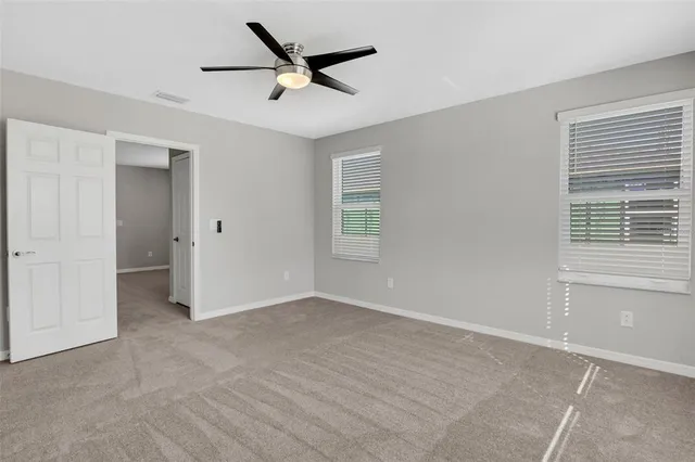 a view of a livingroom with a ceiling fan and window