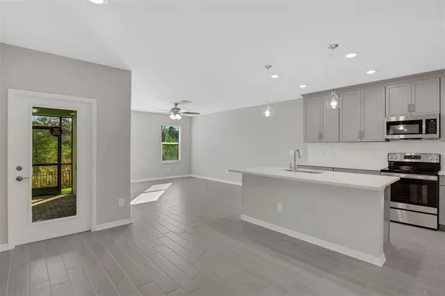 a view of kitchen with sink and refrigerator
